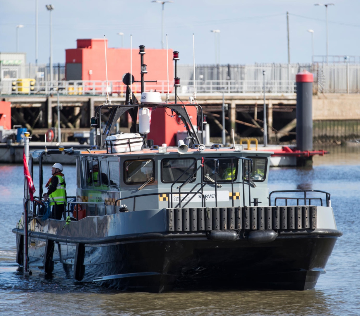 Commercial Rib Charter survey vessel operating in port waters, with crew on deck conducting marine inspection and coastal infrastructure survey work