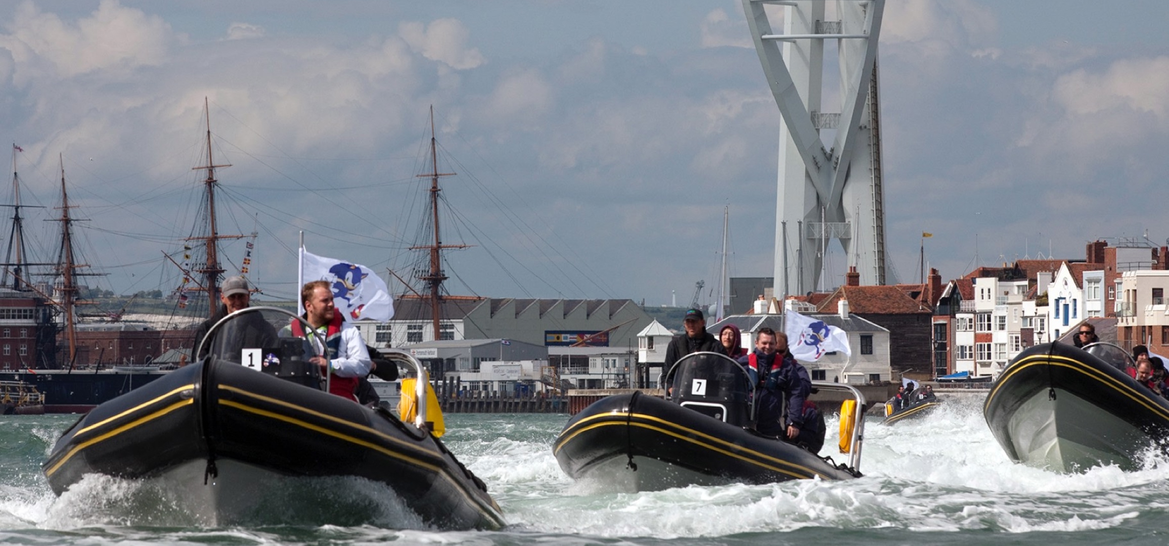 Solent Rib Charter guests riding high-speed RIB boats through Portsmouth Harbour, with historic ships and the Spinnaker Tower in the background.