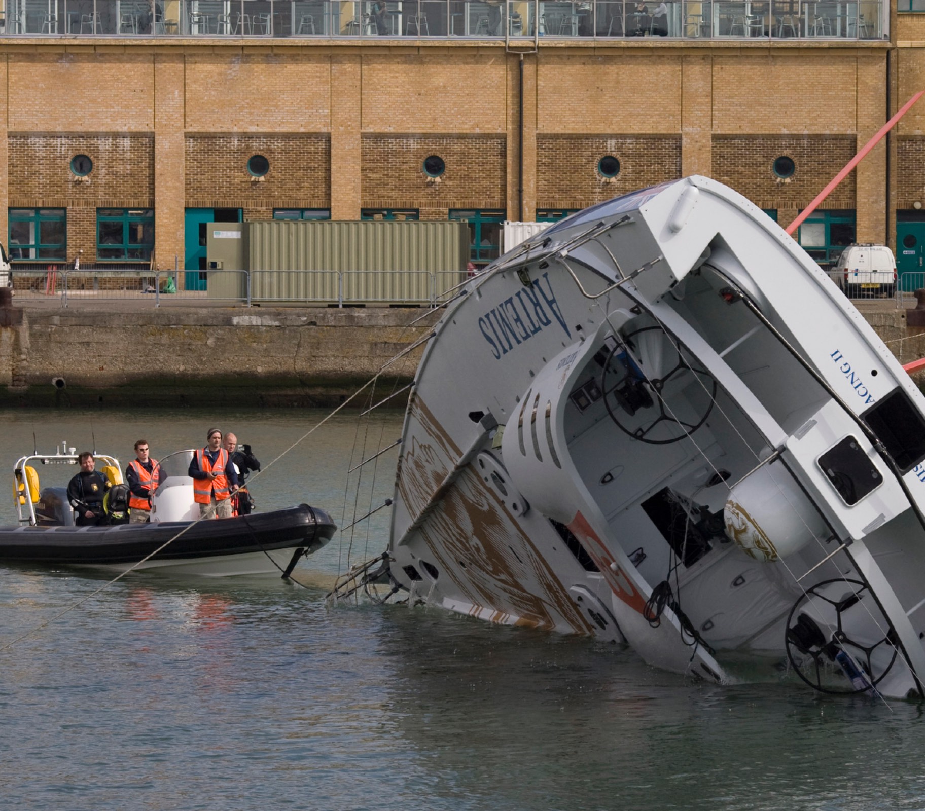 RIB boat assisting with the recovery of a partially submerged vessel in a harbour