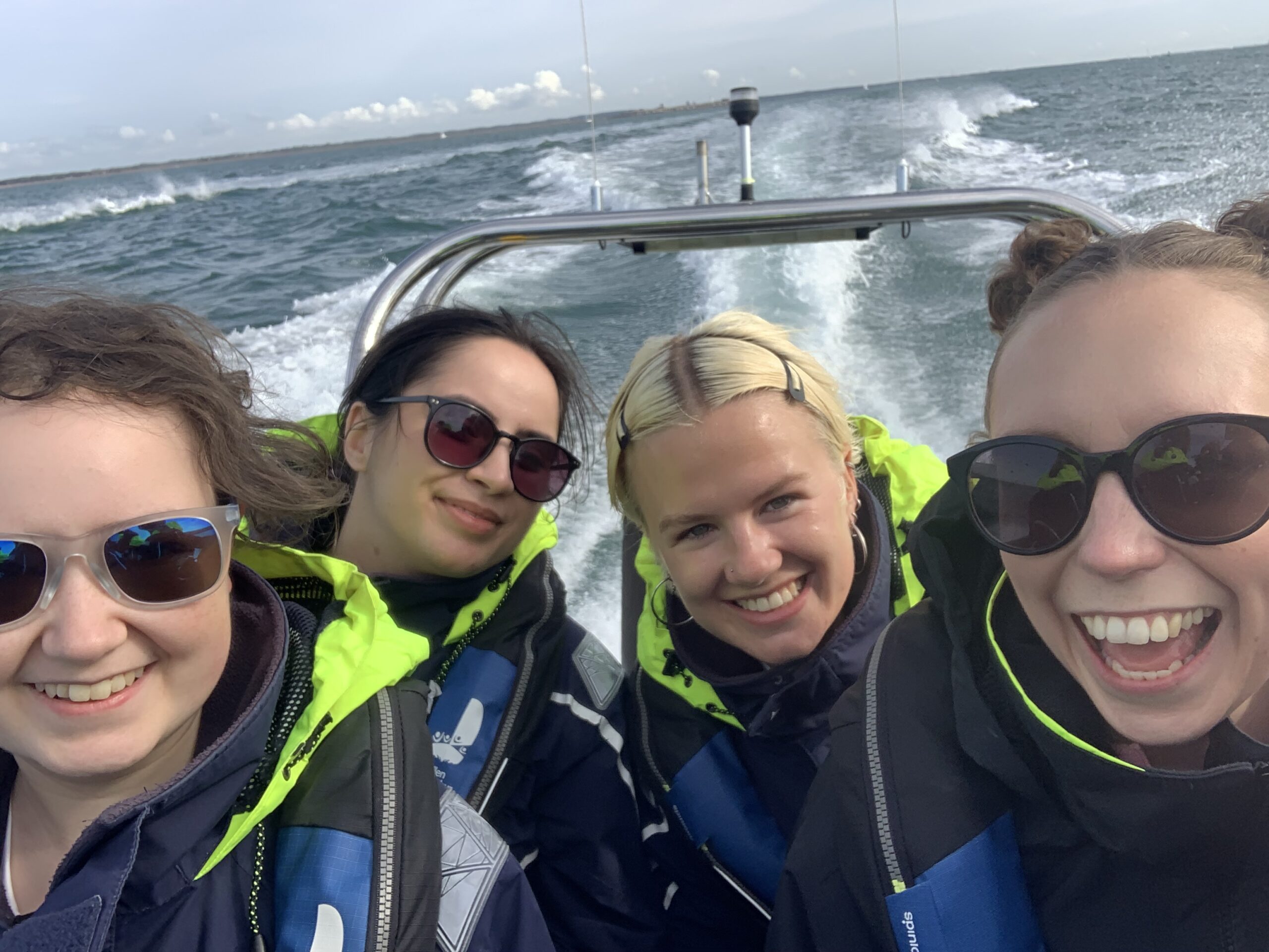 Group enjoying a high-speed Solent RIB boat experience with Solent Rib Charter, wake visible behind the boat